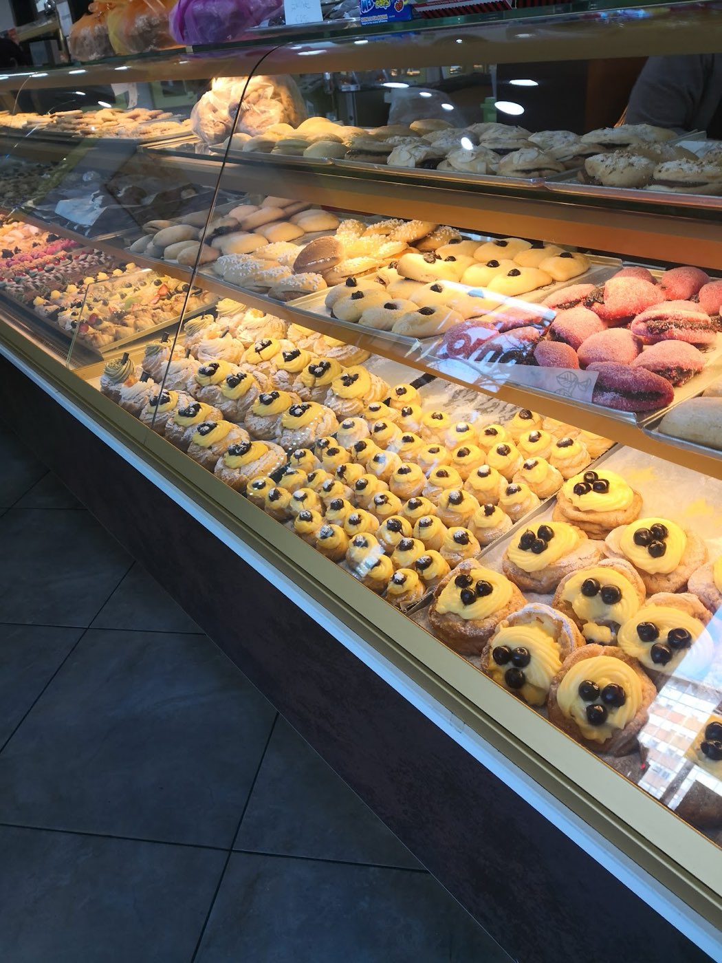 La vetrina dei dolci con zeppole e choux alla crema